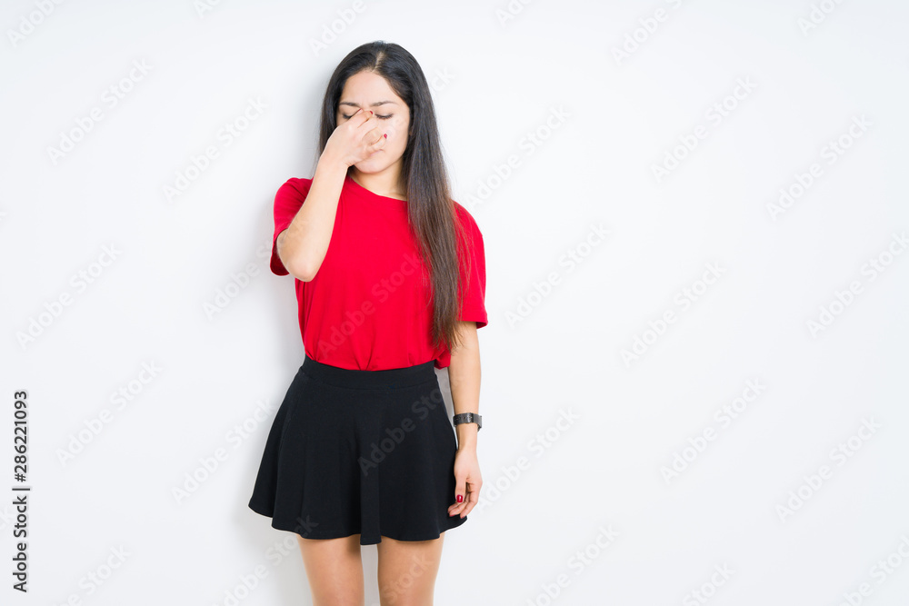 Beautiful brunette woman wearing red t-shirt and skirt over isolated background tired rubbing nose and eyes feeling fatigue and headache. Stress and frustration concept. Beautiful brunette woman wearing red t-shirt and skirt over isolated background tired rubbing nose and eyes feeling fatigue and headache. Stress and frustration concept.