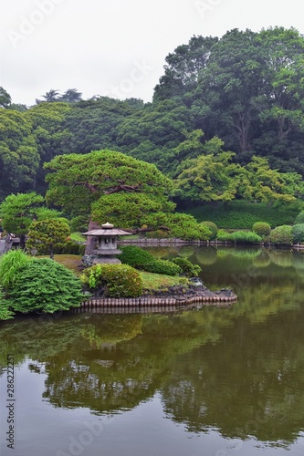 Fototapeta Naklejka Na Ścianę i Meble -  Traditional Japanese gardens in public parks in Tokyo, Japan. Views of stone lanterns, lakes, ponds, bonsai and wildlife walking around paths and trails. Asia. 