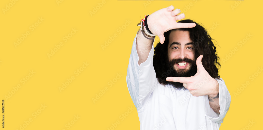 Man wearing Jesus Christ costume smiling making frame with hands and fingers with happy face. Creativity and photography concept. Man wearing Jesus Christ costume smiling making frame with hands and fingers with happy face. Creativity and photography concept.
