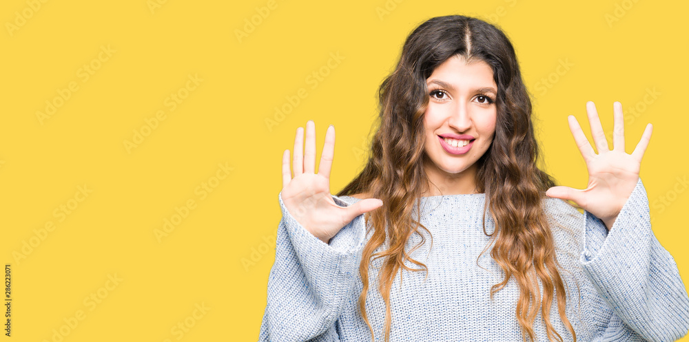 Young beautiful woman wearing winter sweater showing and pointing up with fingers number ten while smiling confident and happy. Young beautiful woman wearing winter sweater showing and pointing up with fingers number ten while smiling confident and happy.
