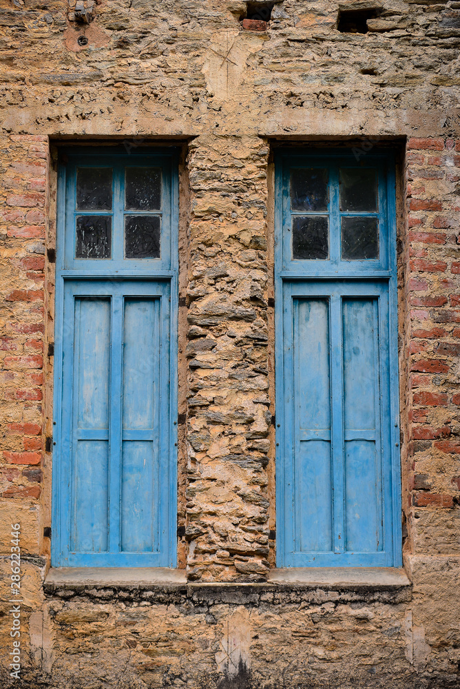 old blue windows with shutters on dilapidated walls old blue windows with shutters on dilapidated walls