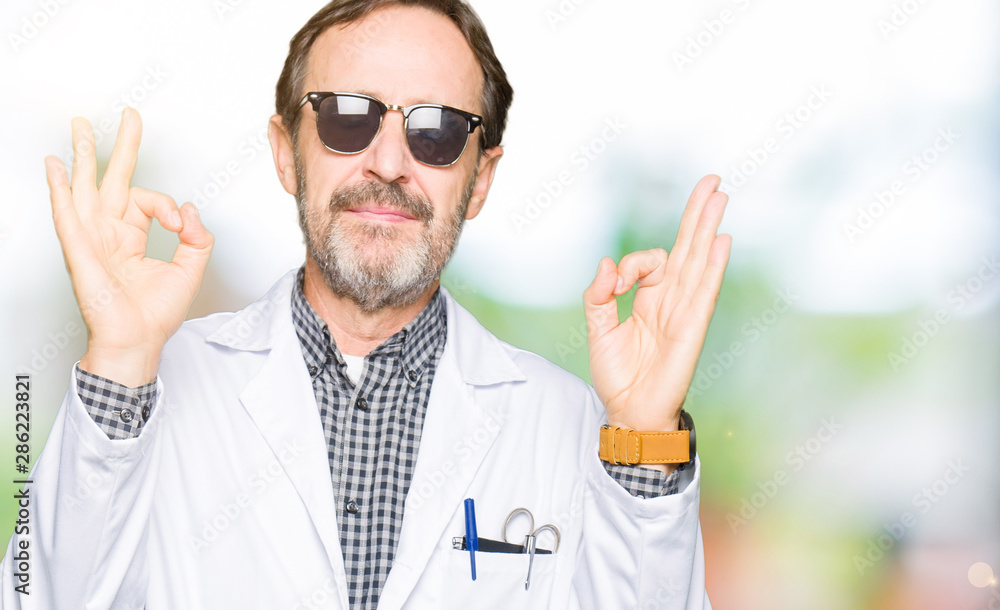 Naklejka premium Handsome middle age doctor man wearing sunglasses relax and smiling with eyes closed doing meditation gesture with fingers. Yoga concept.