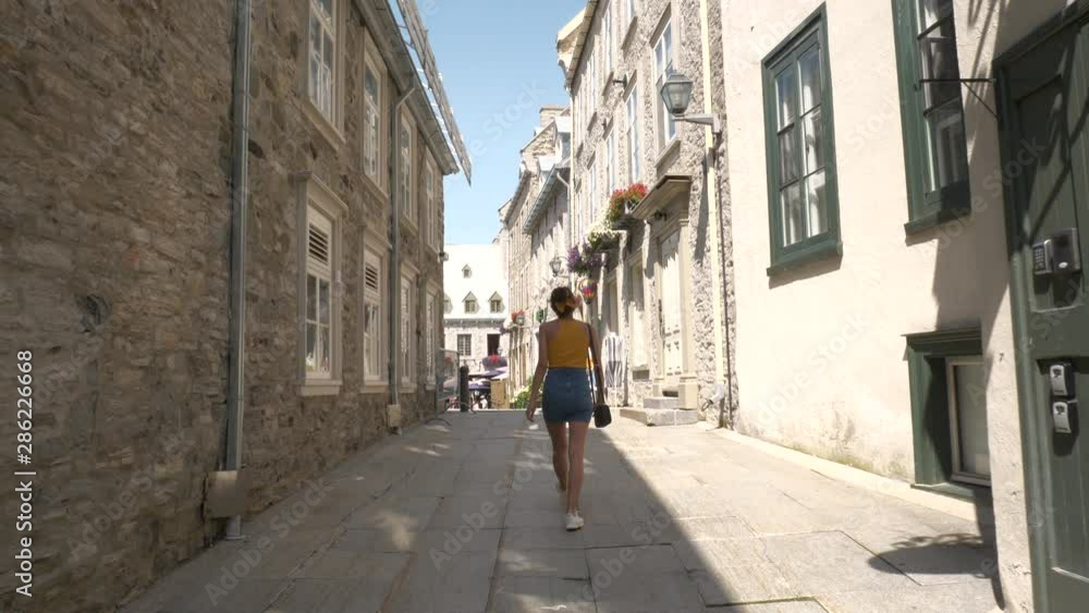 Woman Walking Through Old Town Streets On Vacation, Quebec Woman Walking Through Old Town Streets On Vacation, Quebec