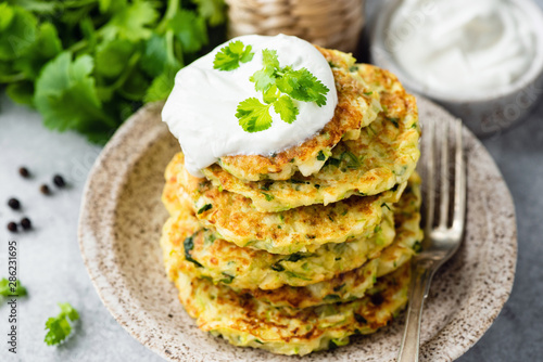Canvas Print Zucchini fritters or pancakes stack with sour cream on top