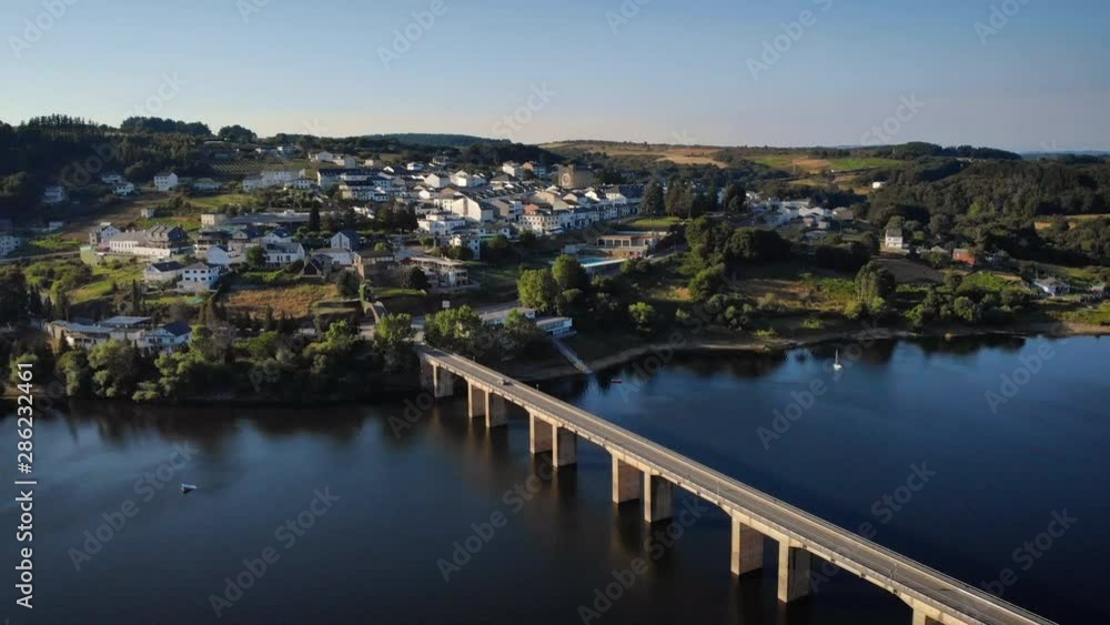 Aerial view of Portomarin, Spanish village along the French Way of the Camino de Santiago or Way of Saint James. Urban landscape with bridge and lake in Spain seen from drone flying in sky Aerial view of Portomarin, Spanish village along the French Way of the Camino de Santiago or Way of Saint James. Urban landscape with bridge and lake in Spain seen from drone flying in sky