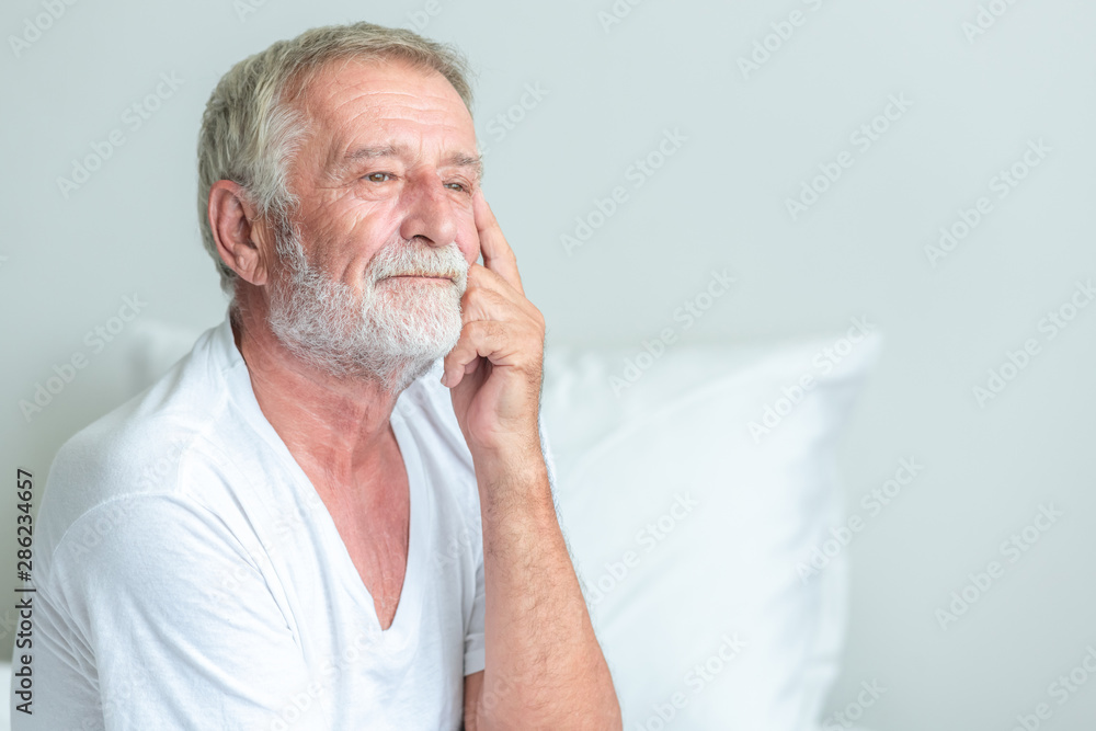 Senior man sitting in bed, unhapppy pose. Senior man sitting in bed, unhapppy pose.