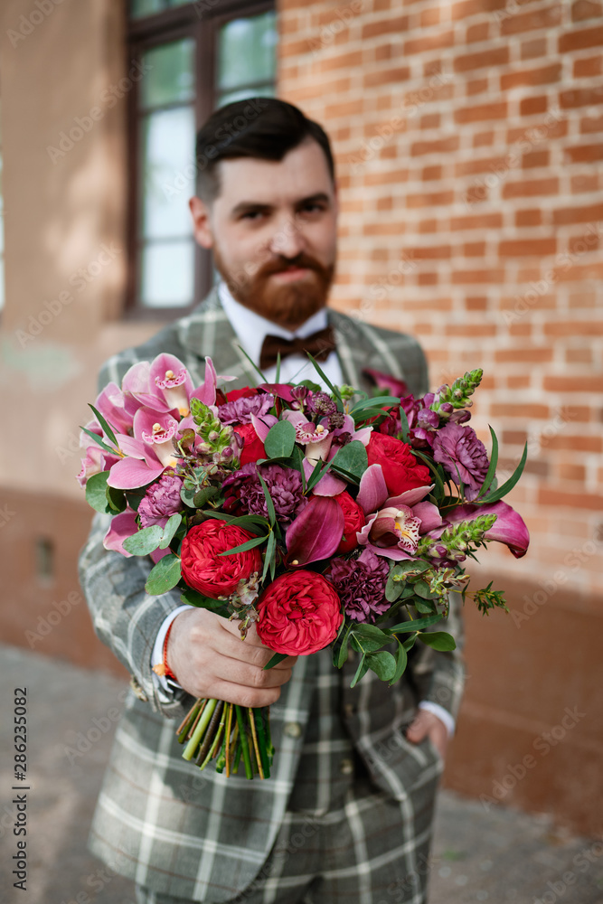 Fototapeta premium Man Clothed Stylish Suit Holding Bouquet of Flower