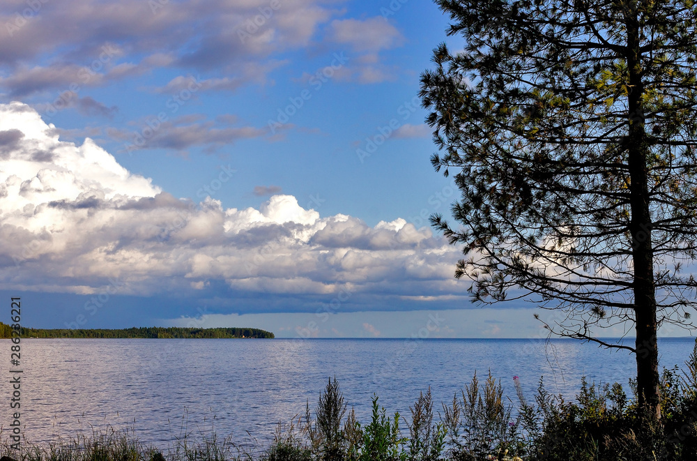 Evening water landscape of Lake Onega against the sky with clouds