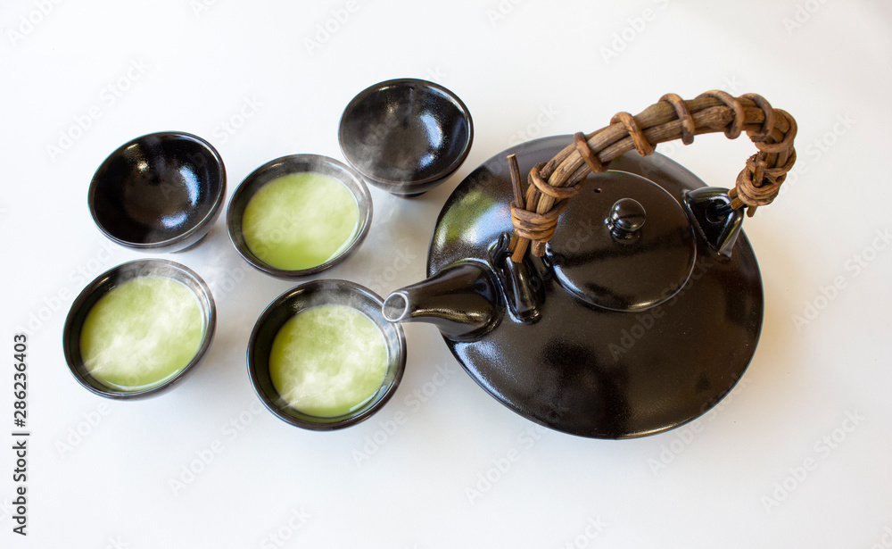 Asian clay teapot with hot green tea bowls on white background,Asian culture concept, Asian clay teapot with hot green tea bowls on white background,Asian culture concept,