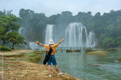 Women are watching Ban Gioc or Detain waterfall flow down fluted is famous place travel destination the most popular one of the top 10 waterfalls in the world along Cao Bang  Vietnam and China border