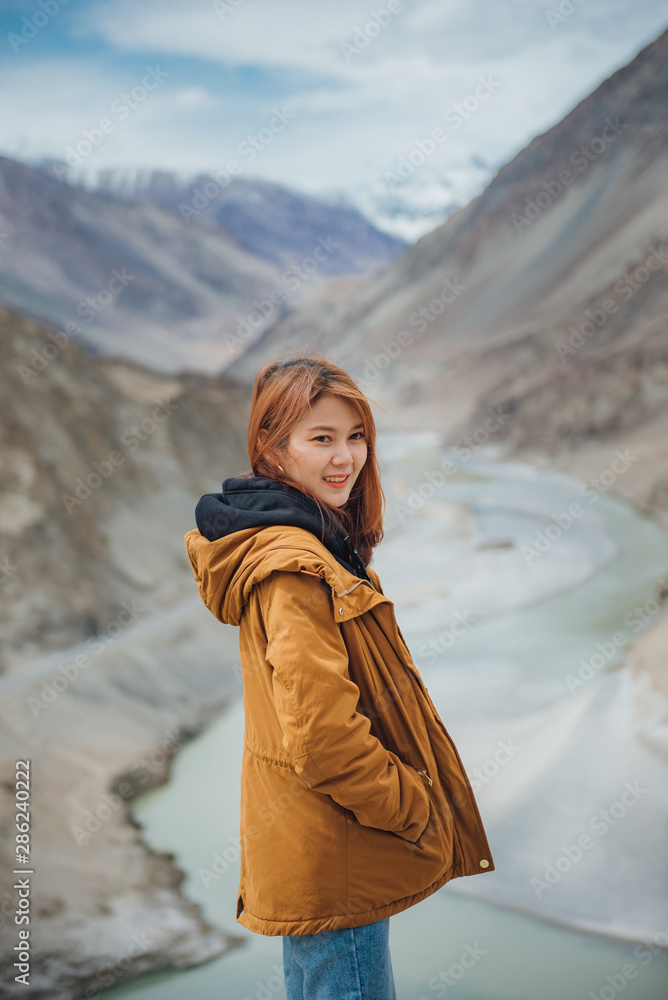 Φωτογραφία Young asian woman traveler enjoy traveling at confluence of zanskar and indus rivers in leh, ladakh, india
