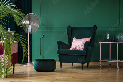 Velvet pouf and chair in bottle green interior