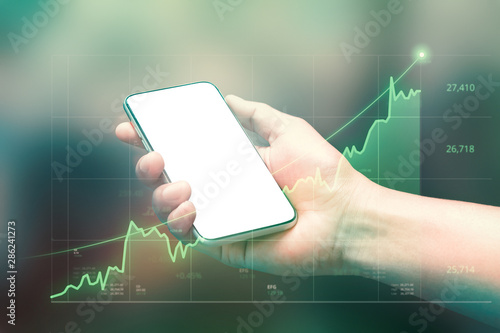 Businessman holding smartphone and showing holographic graphs and stock market statistics gain profits. Concept of growth planning good economy and business strategy. ( Clipping path screen ) photo