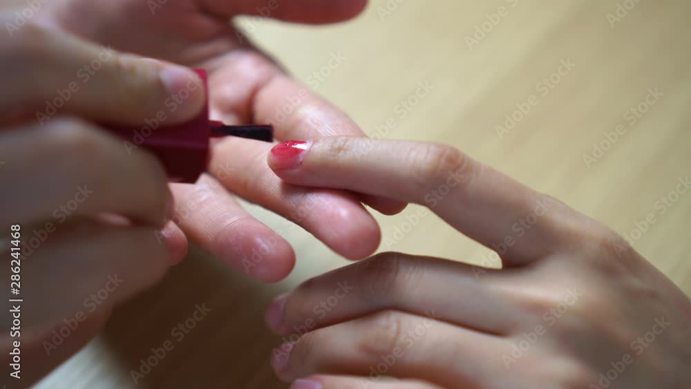 Woman applying nail polish for new manicure. Woman applying nail polish for new manicure.