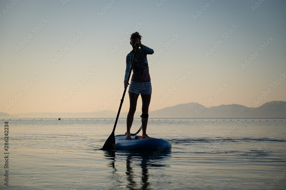 Young woman paddling on a sup board
