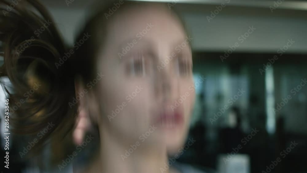 Portrait in close-up of a woman running on a treadmill and sweating in a fitness club - close-up view - sport concept Portrait in close-up of a woman running on a treadmill and sweating in a fitness club - close-up view - sport concept