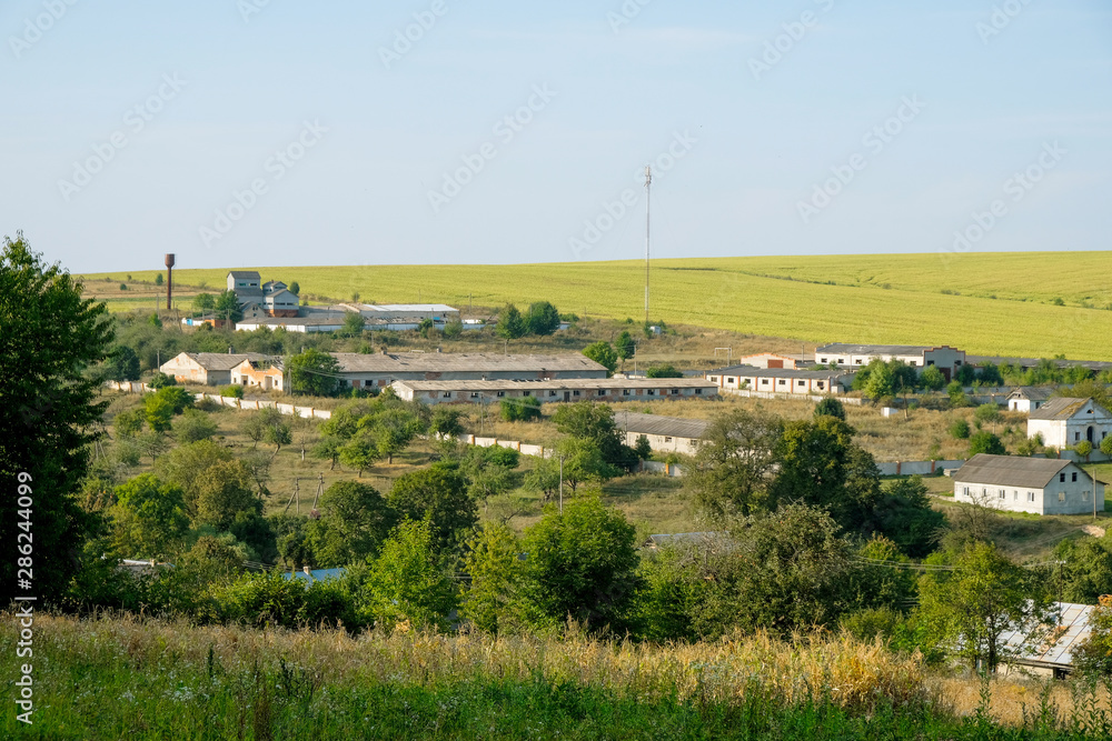 Farm yard with cowsheds and farm buildings in the valley of Porokhova village in Ukraine Copy space.