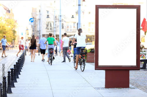 Bilbord reklamowy w centrum miasta Wrocław, w tle rowerzyści na rowerach.