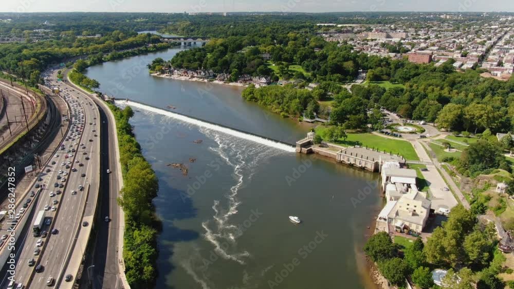 Beautiful high aerial descending shot above Schuylkill River, with express traffic, green park, and Philadelphia residential areas during sunny summer day Beautiful high aerial descending shot above Schuylkill River, with express traffic, green park, and Philadelphia residential areas during sunny summer day