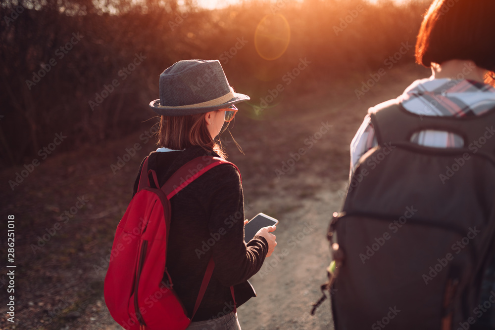 Teenage girl hiking with her mother and using smart phone Teenage girl hiking with her mother and using smart phone