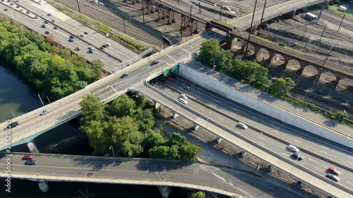 Aerial drone top down shot of traffic flowing smoothly on a bright summer day, train tracks, transportation concept