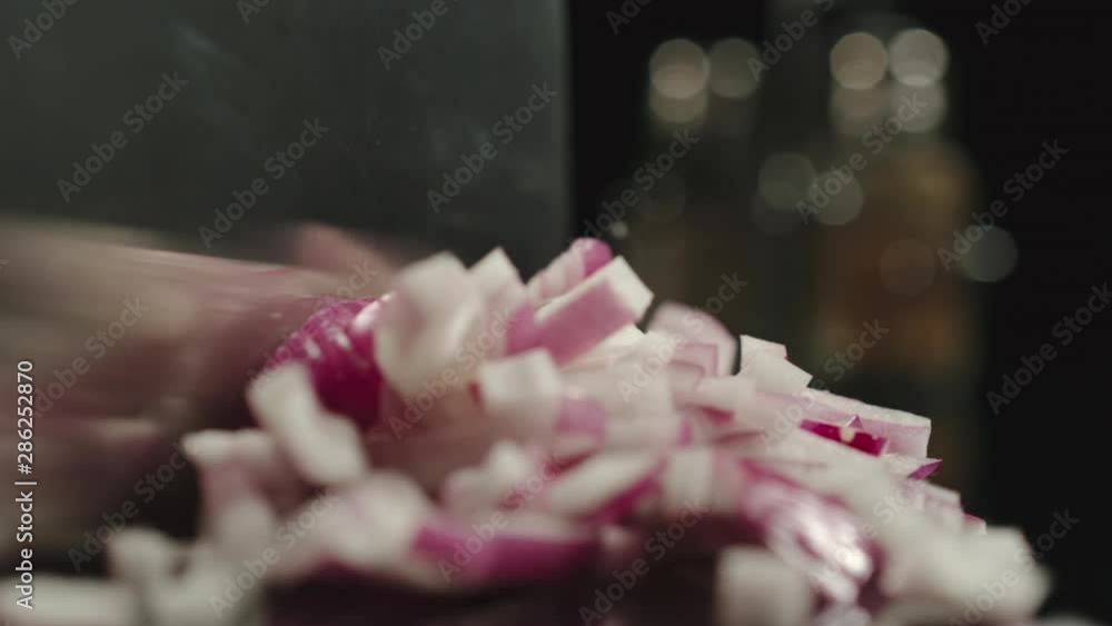 SLOW MOTION: Cook Cutting A Head Of Fresh Red Onion On A Black Table SLOW MOTION: Cook Cutting A Head Of Fresh Red Onion On A Black Table