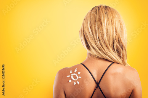 Girl in swimsuit with a sun made with sunscreen.