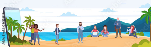 people using gadgets mix race men women relaxing on tropical island sea beach summer vacation digital addiction concept smartphone screen mobile app flat full length horizontal