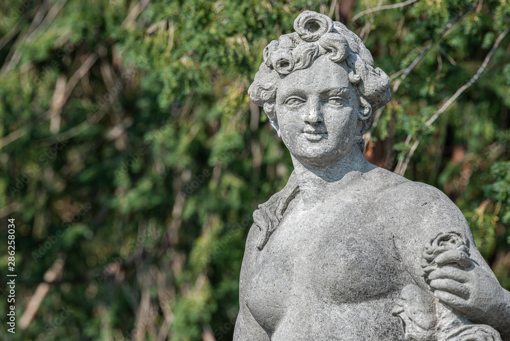 Old statue of a sensual naked Renaissance era woman during bathing in park of Potsdam, Germany