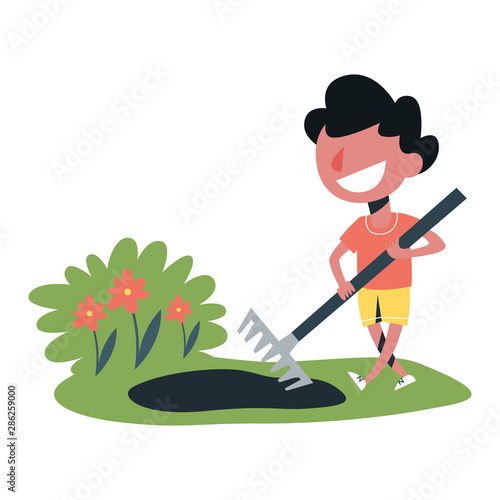 Boy working in the garden with rake. Adorable boy gardening