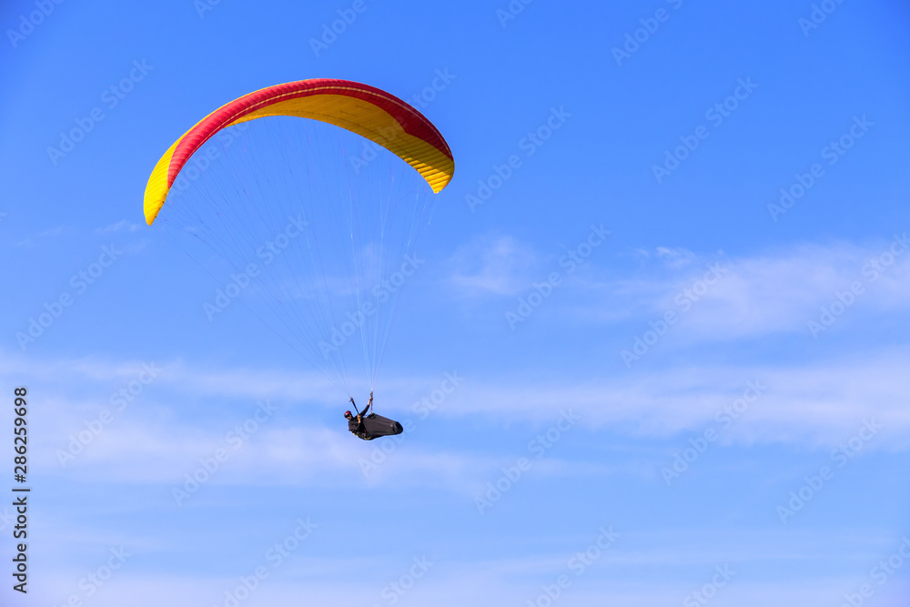 Paraglider flying on the background of blue sky with clouds, freedom concept Paraglider flying on the background of blue sky with clouds, freedom concept