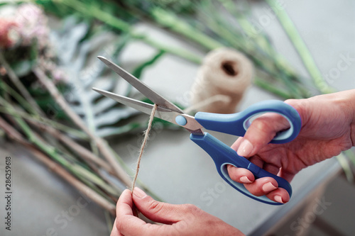 Woman with accurate light manicure carrying metal scissors