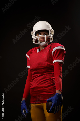 Photo of woman in helmet American football player on empty black background