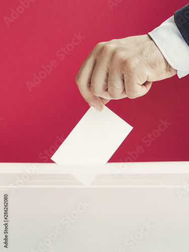 Man putting an empty ballot in a box