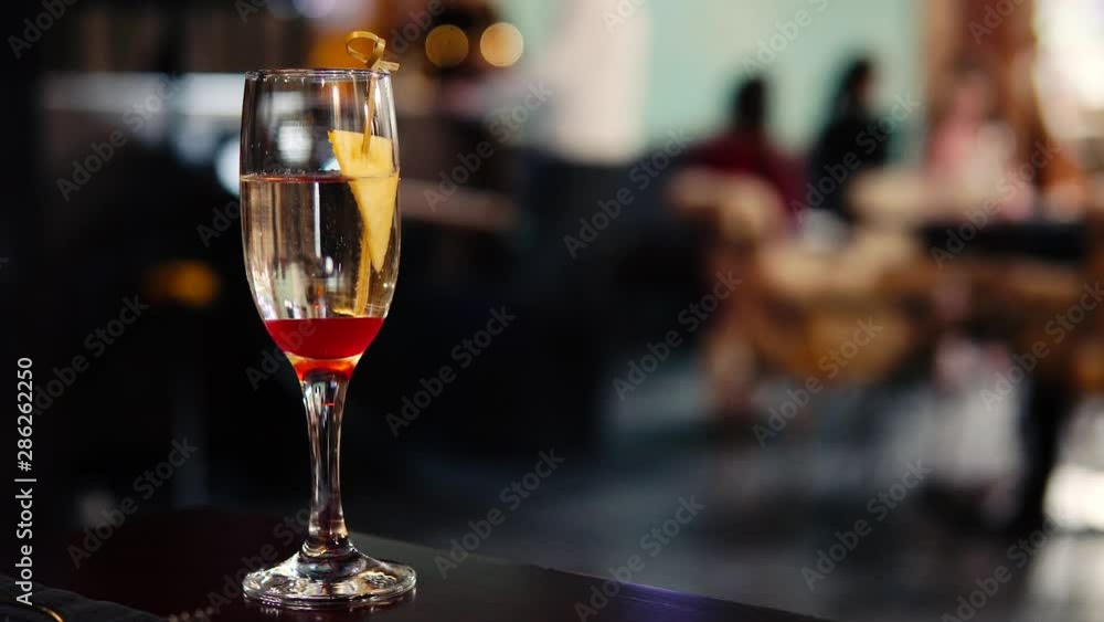 Blurred image of the interior of the restaurant. Defocused people with different activities. A glass of wine in the foreground. Blurred image of the interior of the restaurant. Defocused people with different activities. A glass of wine in the foreground.