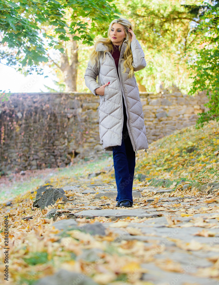 Puffer fashion trend concept. Oversized jacket trend. Puffer jacket casual  and comfortable style. Girl fashionable blonde walk in autumn park. Woman  wear warm grey jacket. Jacket everyone should have Stock Photo