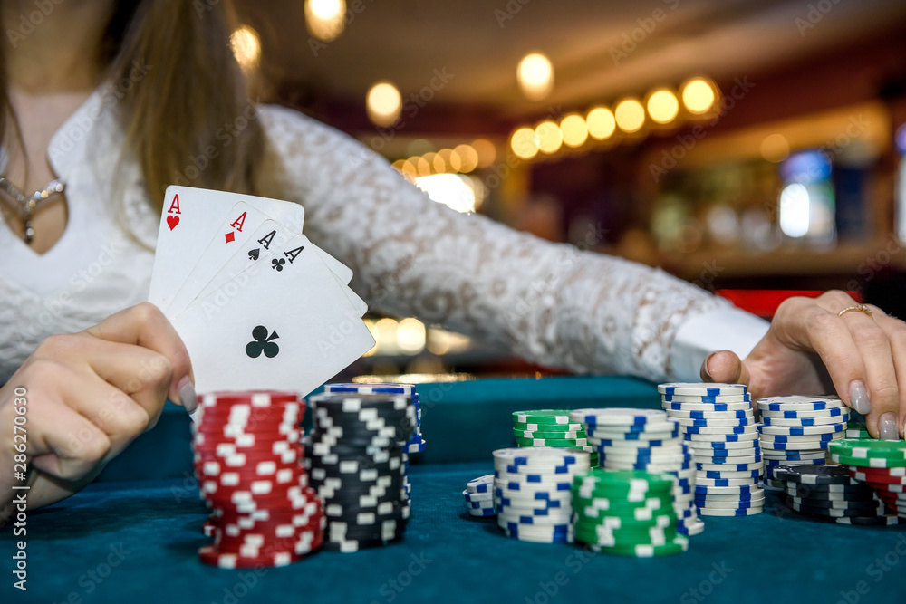 © RomanR - Female hands with playing cards and poker chips
