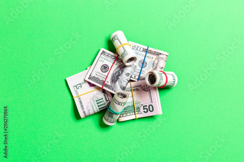 Stacks of one hundred dollars banknotes close-up on colored background business concept top view with copy space photo