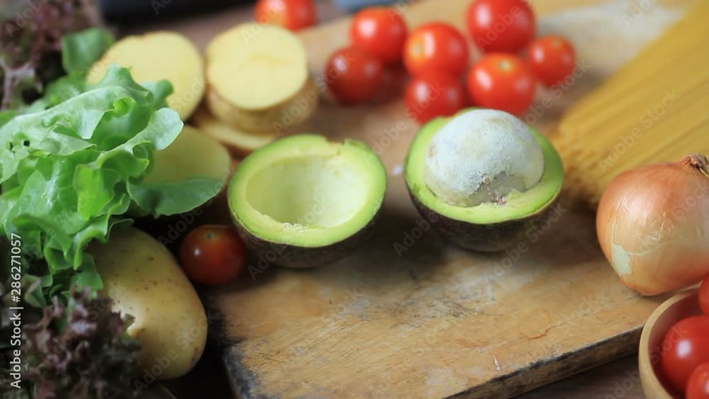 Dieting of Healthy woman put avocado on cutting board to prepare green vegetable and fruit salad. Diet food, Healthy eating and Health care concept. Dieting of Healthy woman put avocado on cutting board to prepare green vegetable and fruit salad. Diet food, Healthy eating and Health care concept.
