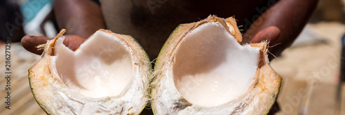 Man with open coconut, panorama photo