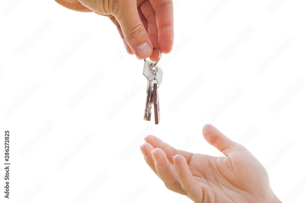 Man giving the metal key from door with wooden trinket in shape of house to the woman Man giving the metal key from door with wooden trinket in shape of house to the woman
