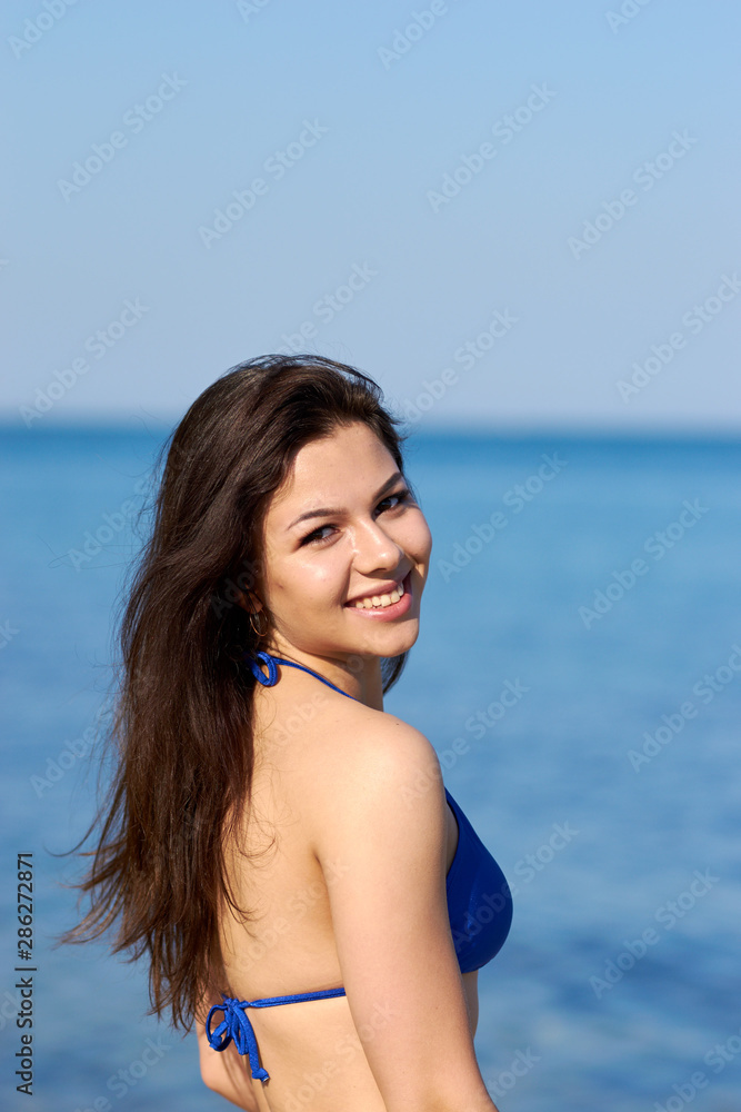 Sexy brunette with a long hair posing in a swimsuit on the beach Sexy brunette with a long hair posing in a swimsuit on the beach