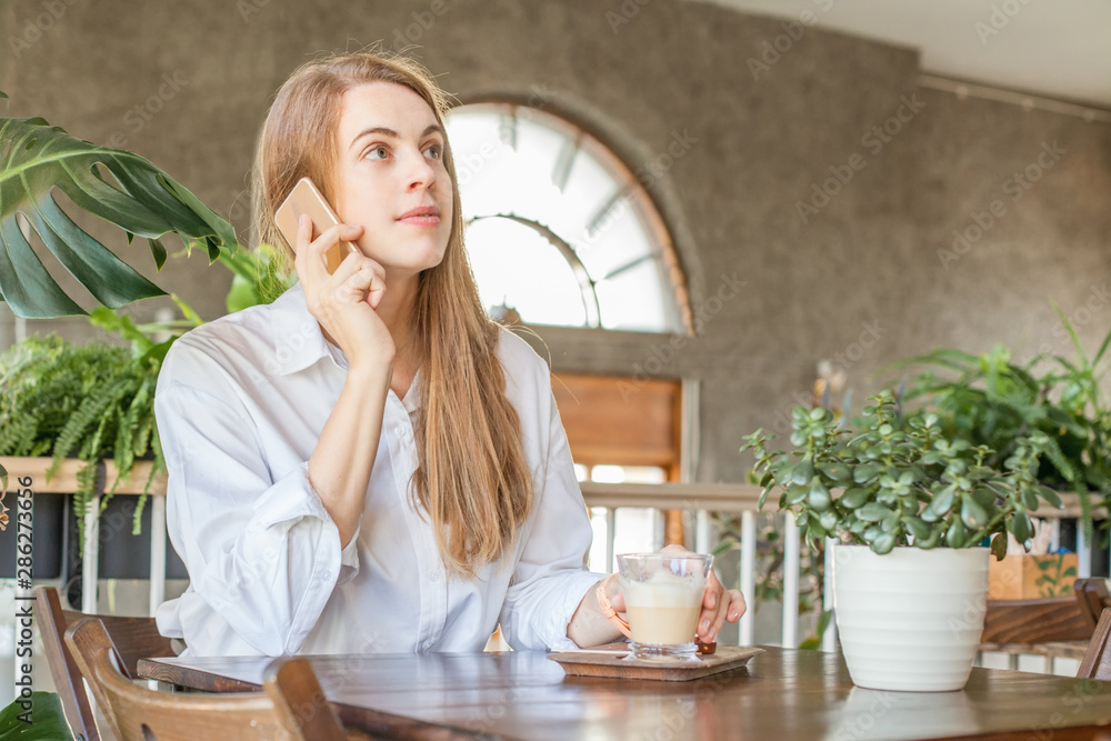 Business woman with smartphone working in open office place Business woman with smartphone working in open office place
