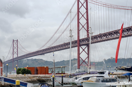 Luxury yachts under the 25 april bridge in Lisbon, Portugal. Port on the Tagus river