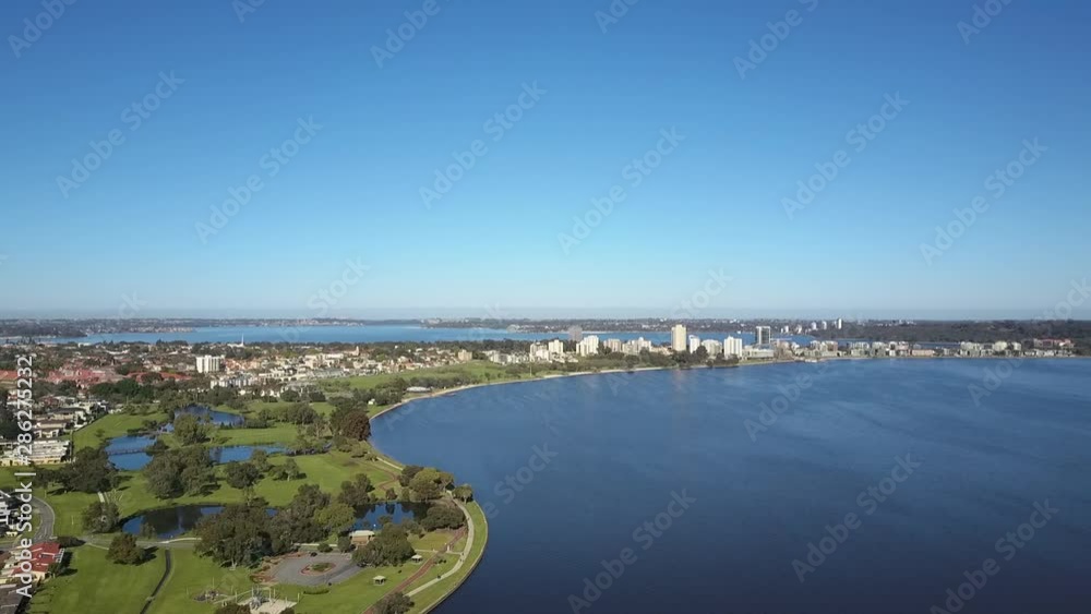 Beautiful scenic aerial view of drone flight above Swan River along the skyline of Perth, capital of Western Australia, with summer sunny blue sky and horizon as background. Beautiful scenic aerial view of drone flight above Swan River along the skyline of Perth, capital of Western Australia, with summer sunny blue sky and horizon as background.