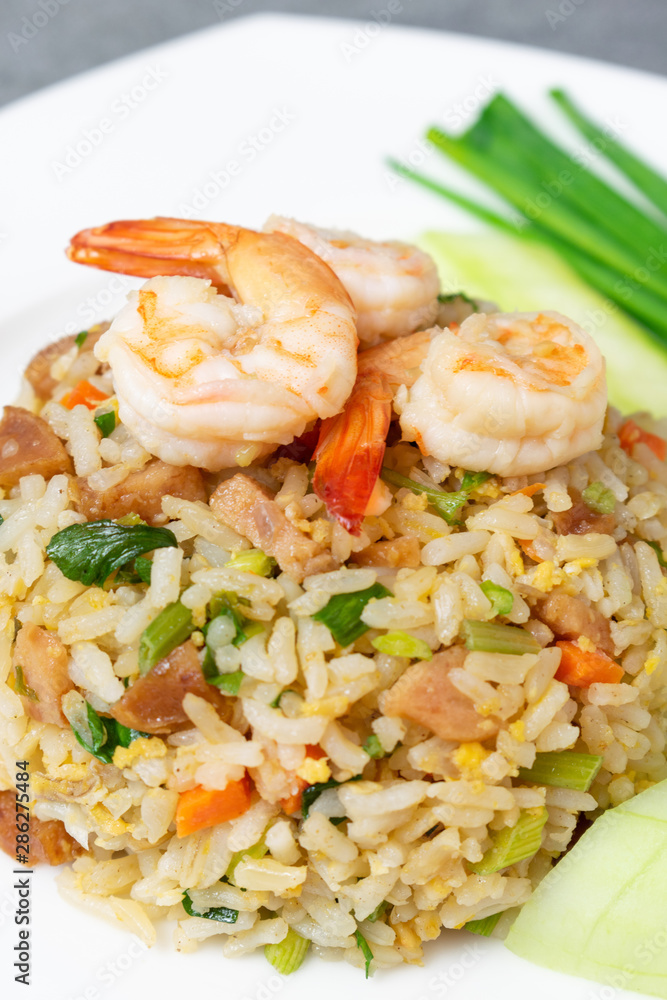 Fried rice with shrimp and Chinese sausage in white plate on concrete table. Fried rice with shrimp and Chinese sausage in white plate on concrete table.