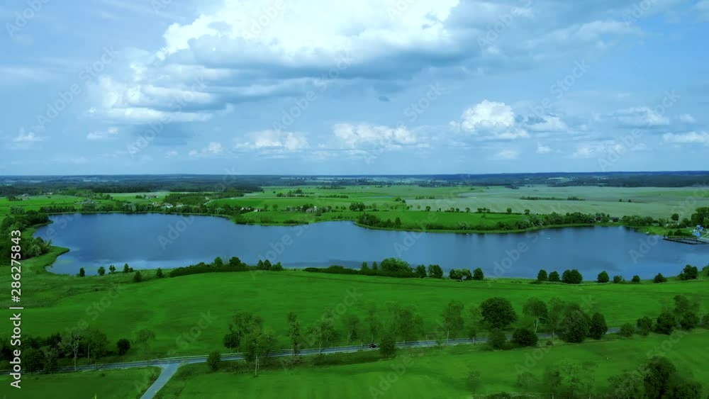 Beautiful aerial view of a lake next to a road and farm in the middle of nature. Beautiful aerial view of a lake next to a road and farm in the middle of nature.