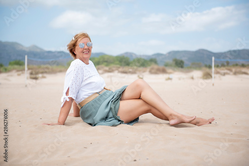 Beautiful mature woman posing on the beach