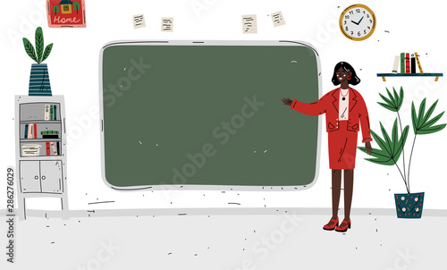 Lesson. Teacher standing near blackboard in classroom.