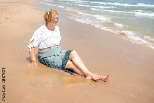 Beautiful mature woman posing on the beach